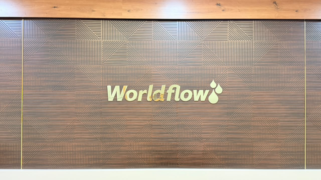 The golden WorldFlow mark on the office signage wall